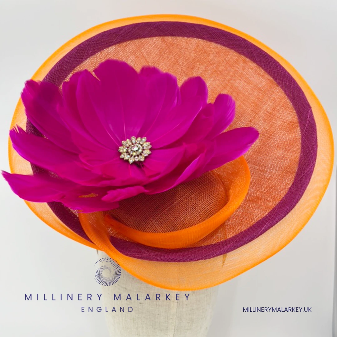 Statement bright orange and pink disc hat with feather flower trim